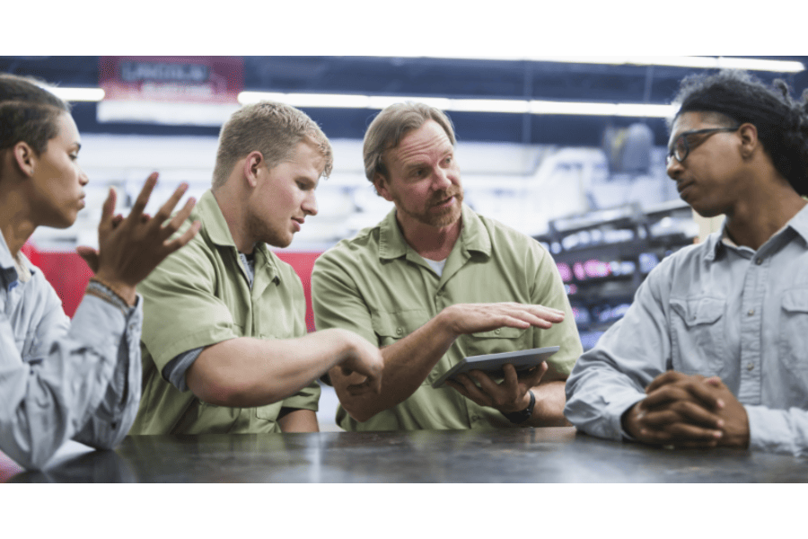 techs training with manager at table with tablet