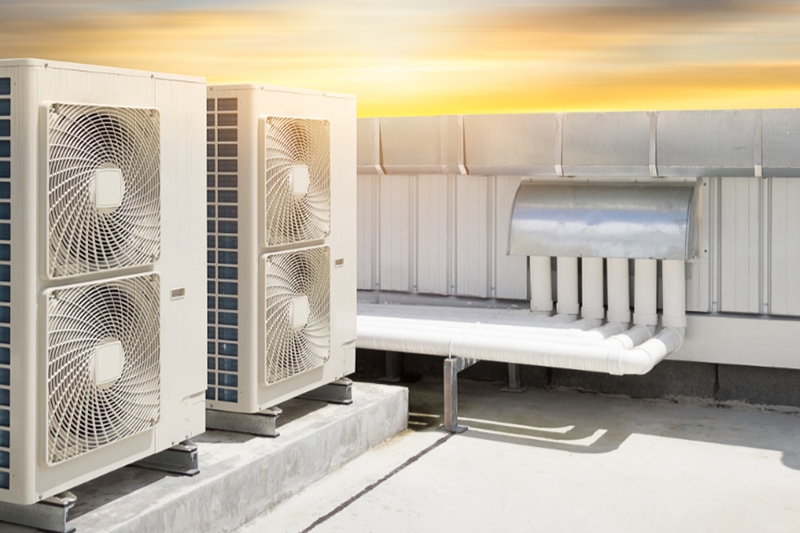 Energy Efficient Units: The Future and The Now of Your Commercial HVAC. Air compressor machine part of air conditioner system on roof deck with sky background.